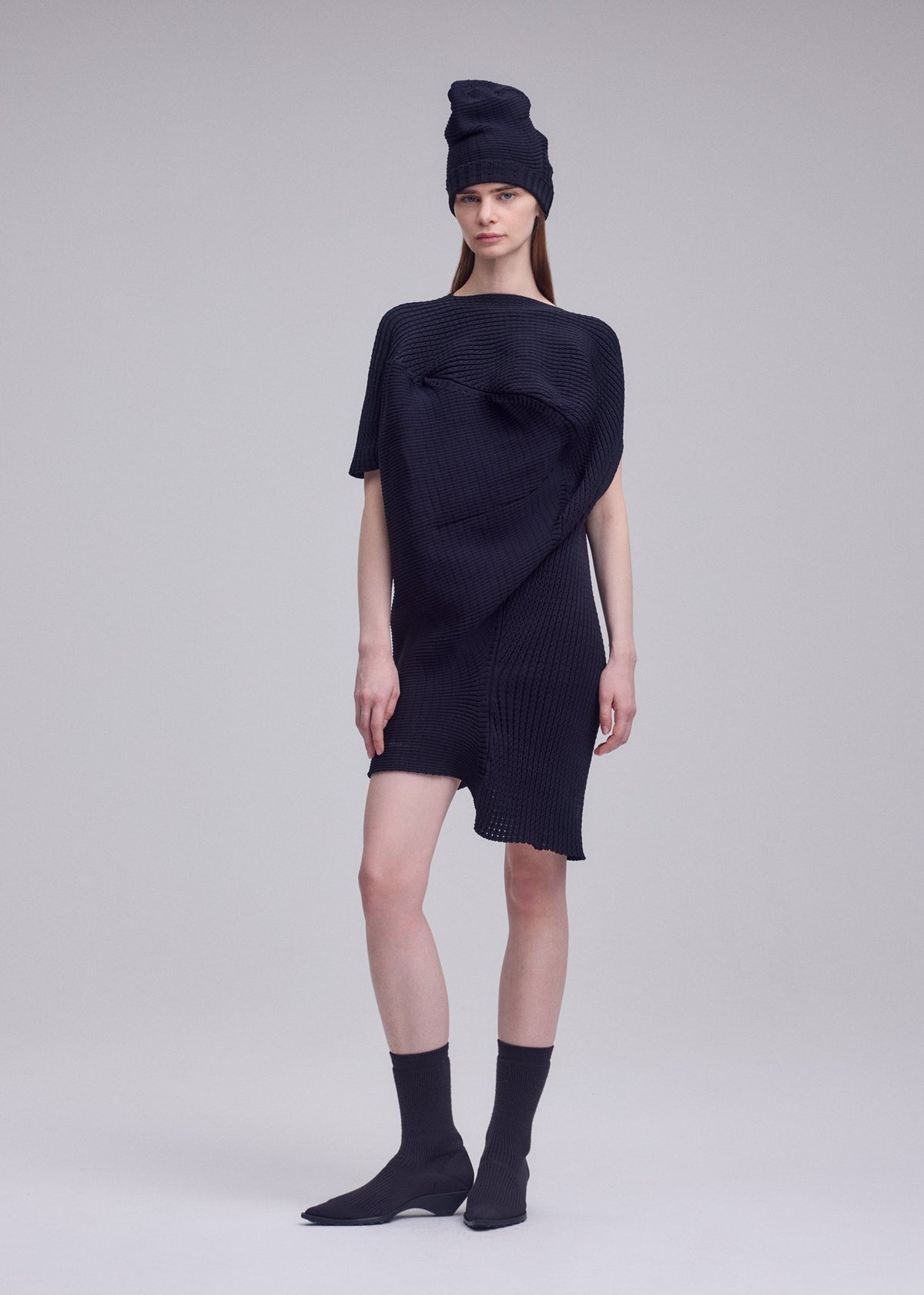 A model wears the ISSEY MIYAKE FOUND STONE found-stone-dress-off-white.