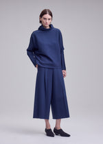 A model wears the ISSEY MIYAKE CAMPAGNE campagne-top-black-10.