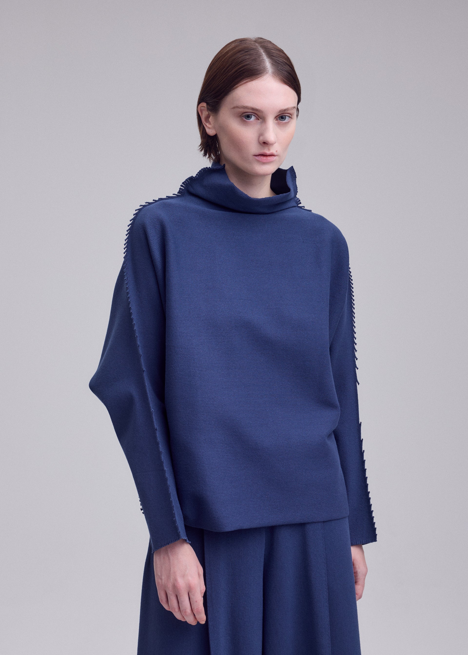 A model wears the ISSEY MIYAKE CAMPAGNE campagne-top-black-10.