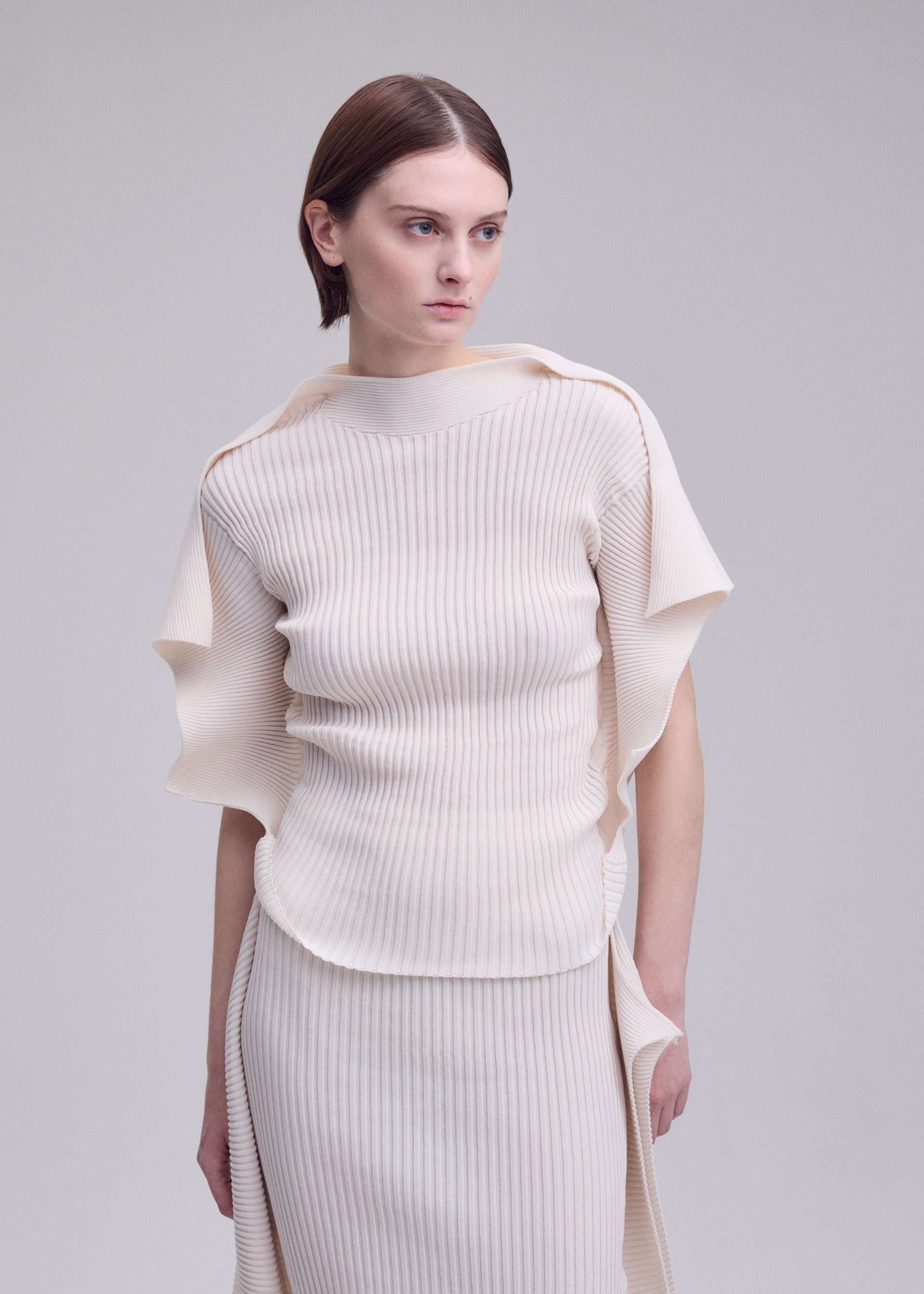 A model wears the ISSEY MIYAKE PRANCE prance-top-ivory.