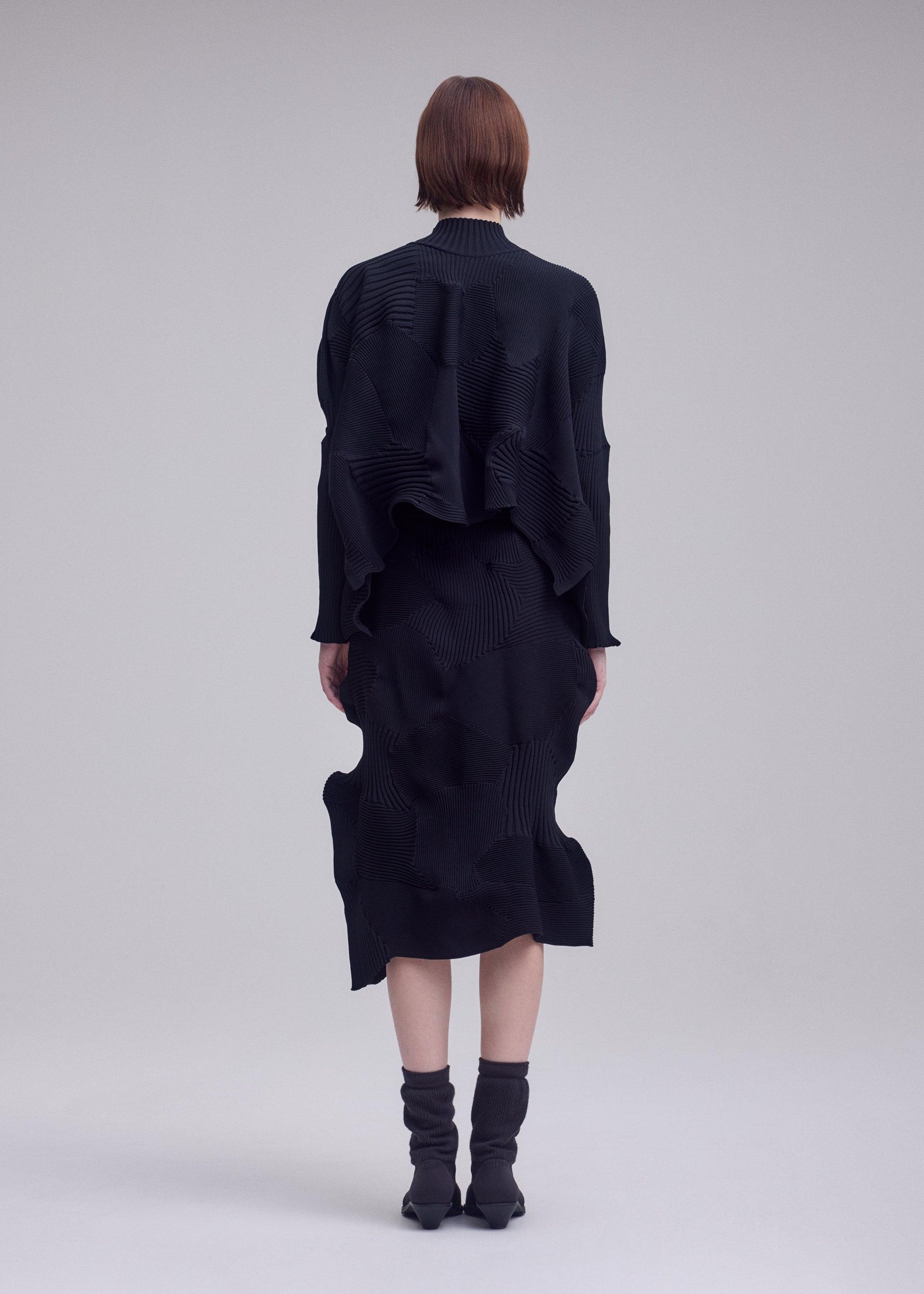 A model wears the ISSEY MIYAKE KONE KONE top.