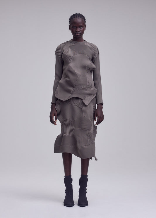 A model wears the ISSEY MIYAKE KONE KONE top.