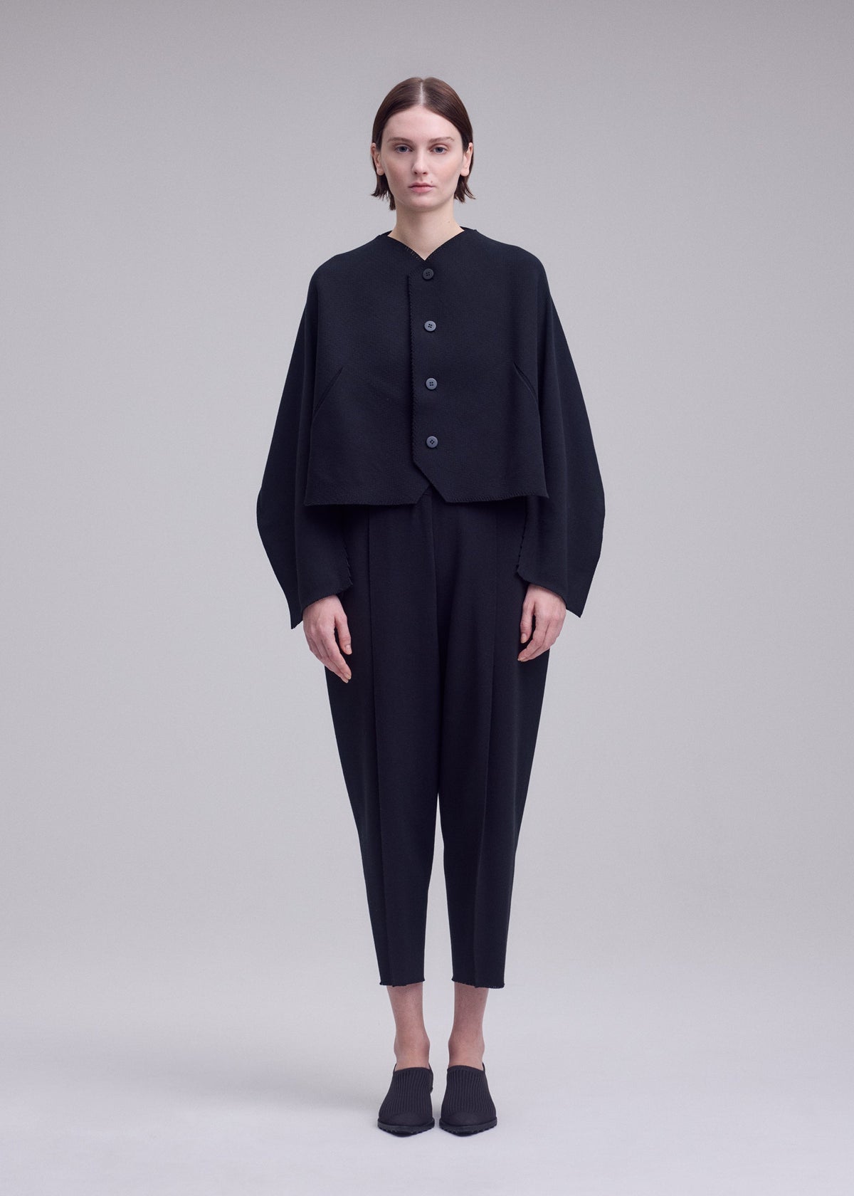 A model wears the ISSEY MIYAKE CAMPAGNE campagne-cardigan-dark-navy-1.