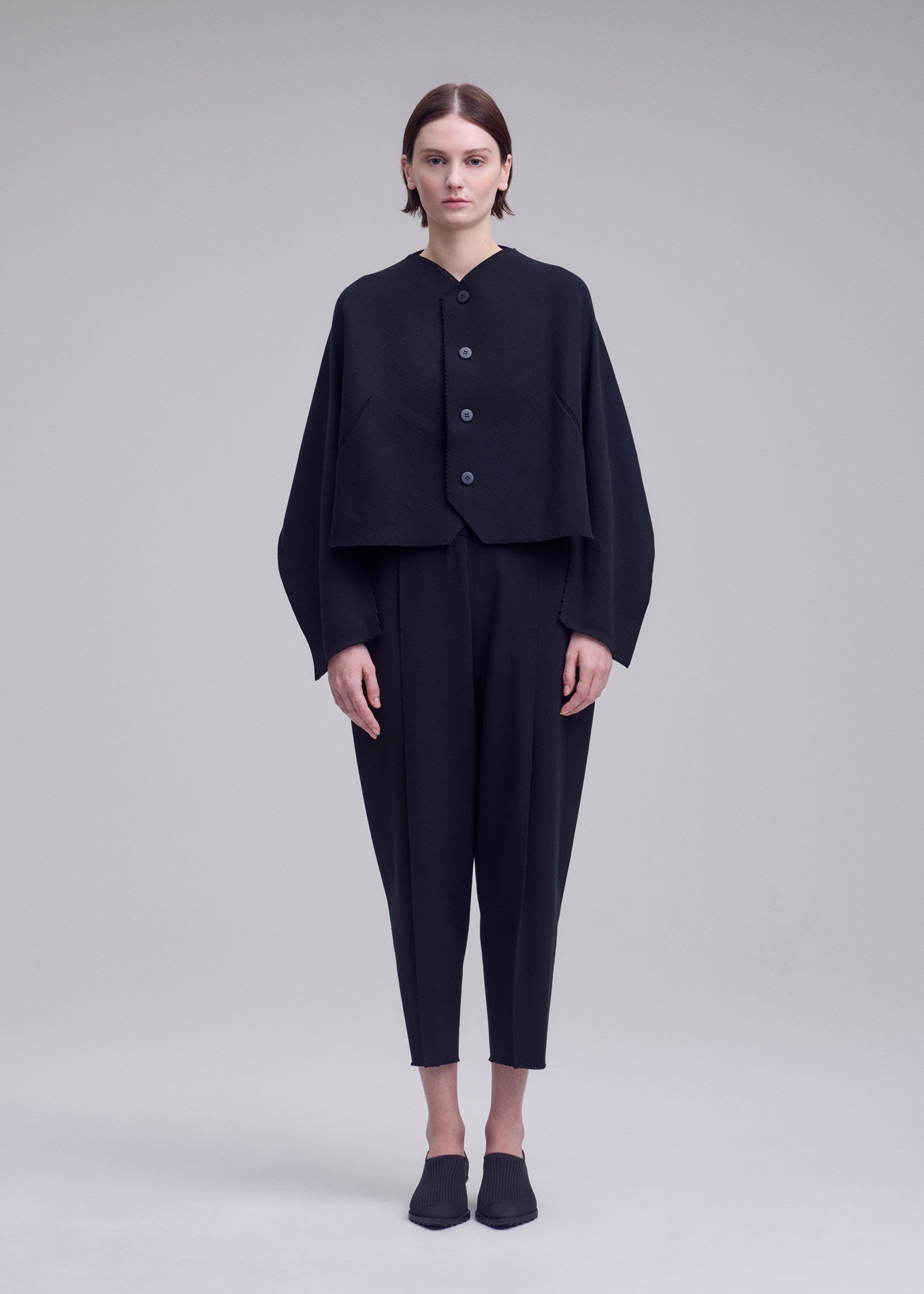 A model wears the ISSEY MIYAKE CAMPAGNE campagne-cardigan-dark-navy-1.