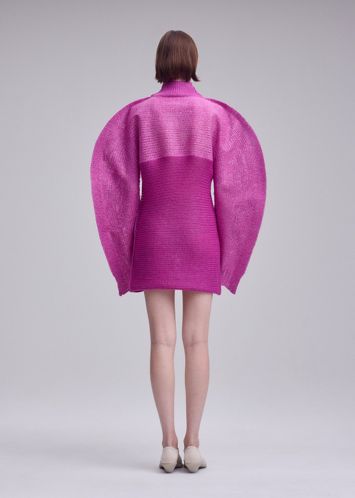 A model wears the ISSEY MIYAKE PANINI PULLED dress.