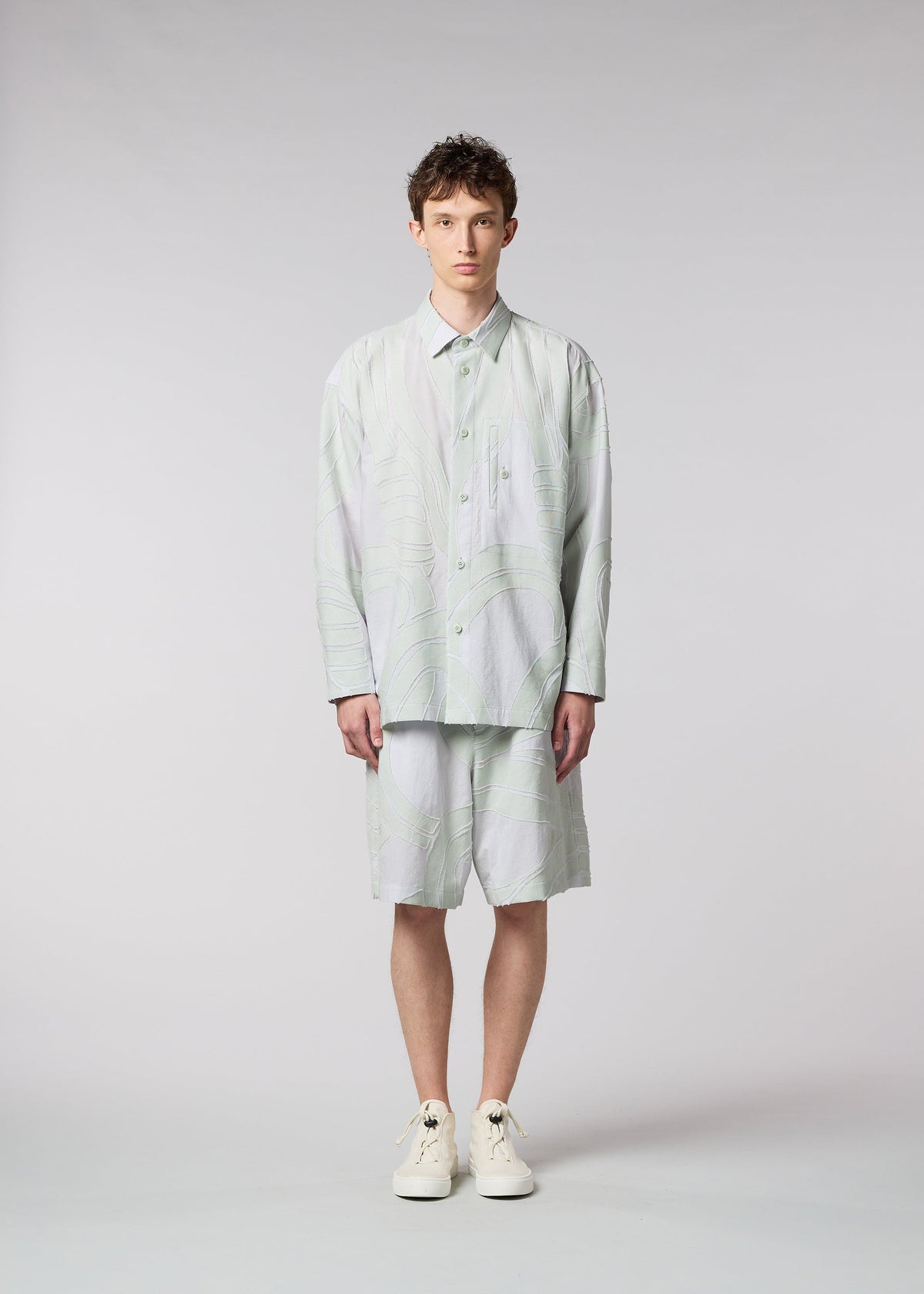 A model wears the ISSEY MIYAKE MEN SCENES shirt.