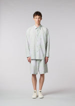 A model wears the ISSEY MIYAKE MEN SCENES shirt.