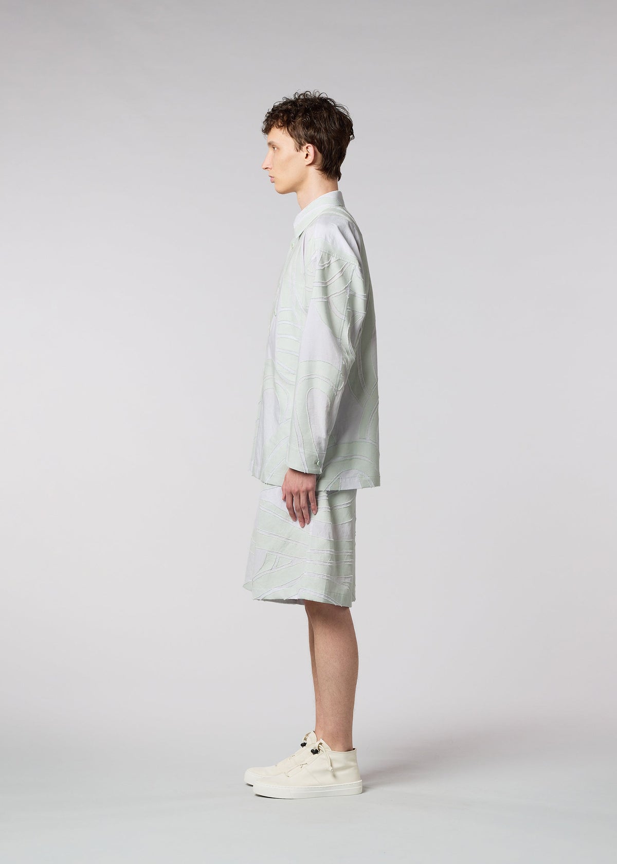 A model wears the ISSEY MIYAKE MEN SCENES shirt.