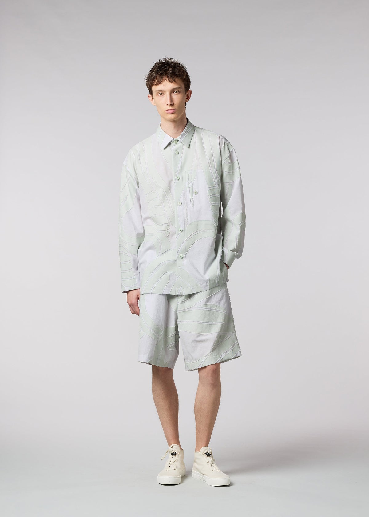 A model wears the ISSEY MIYAKE MEN SCENES shirt.