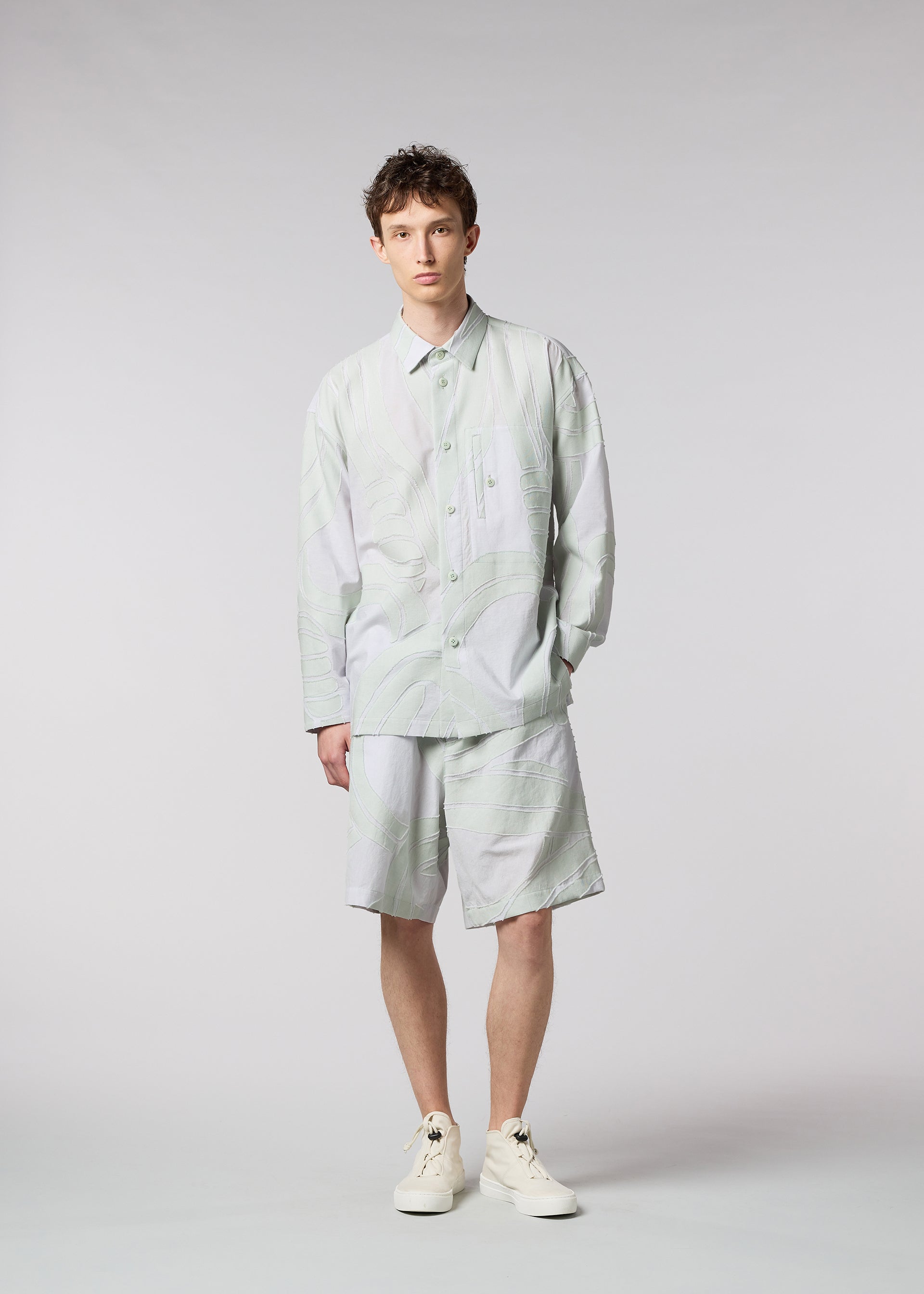 A model wears the ISSEY MIYAKE MEN SCENES shirt.