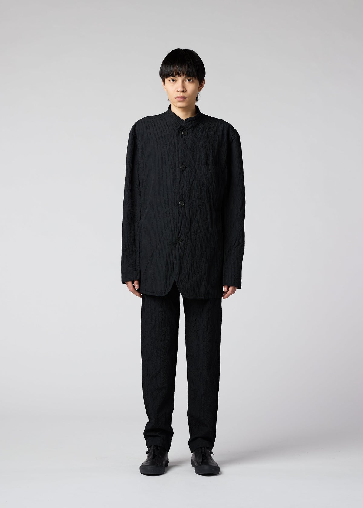 A model wears the IM MEN SHRINK DYE trousers.