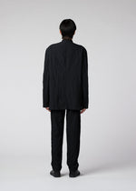 A model wears the IM MEN SHRINK DYE trousers.