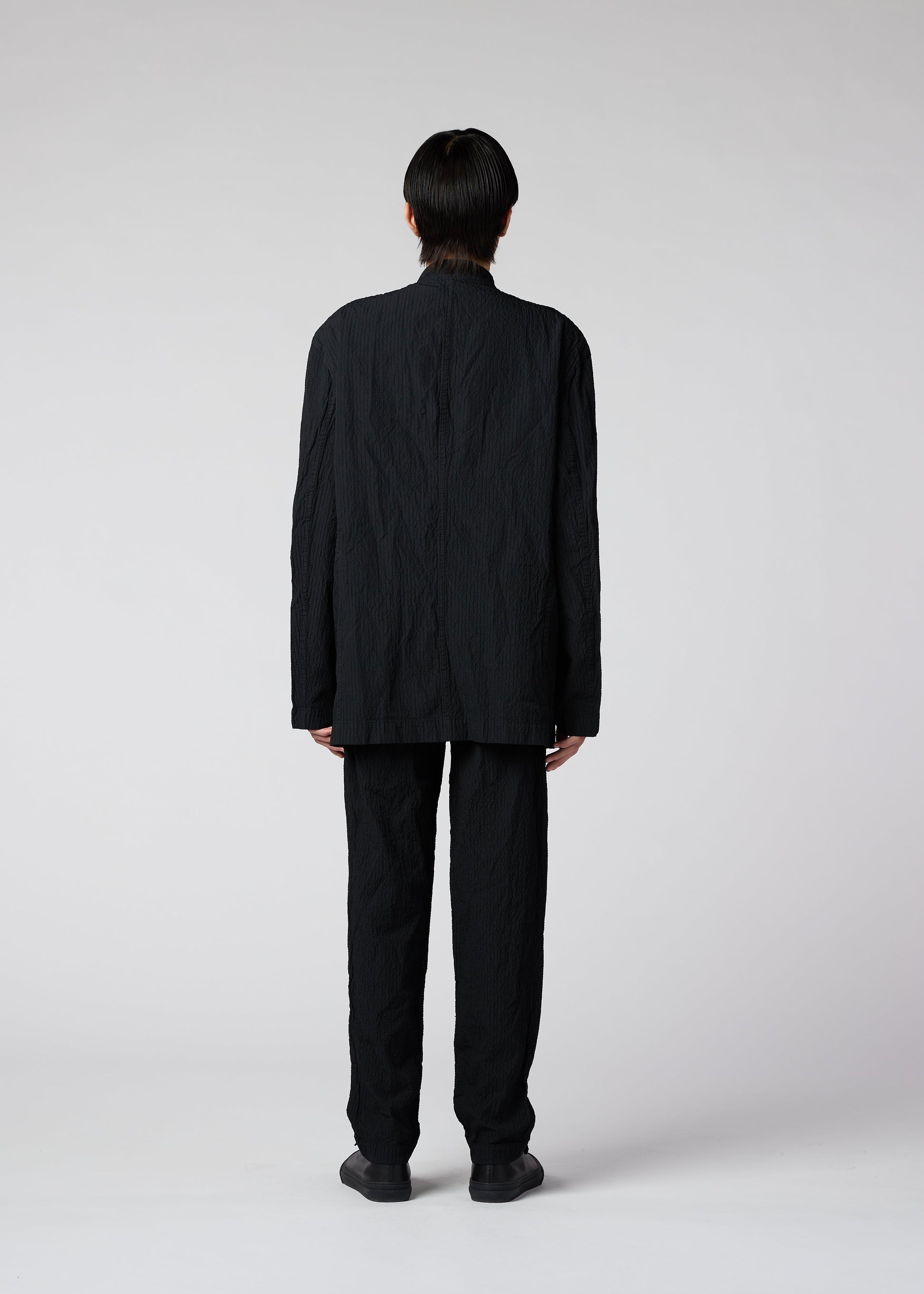 A model wears the IM MEN SHRINK DYE trousers.