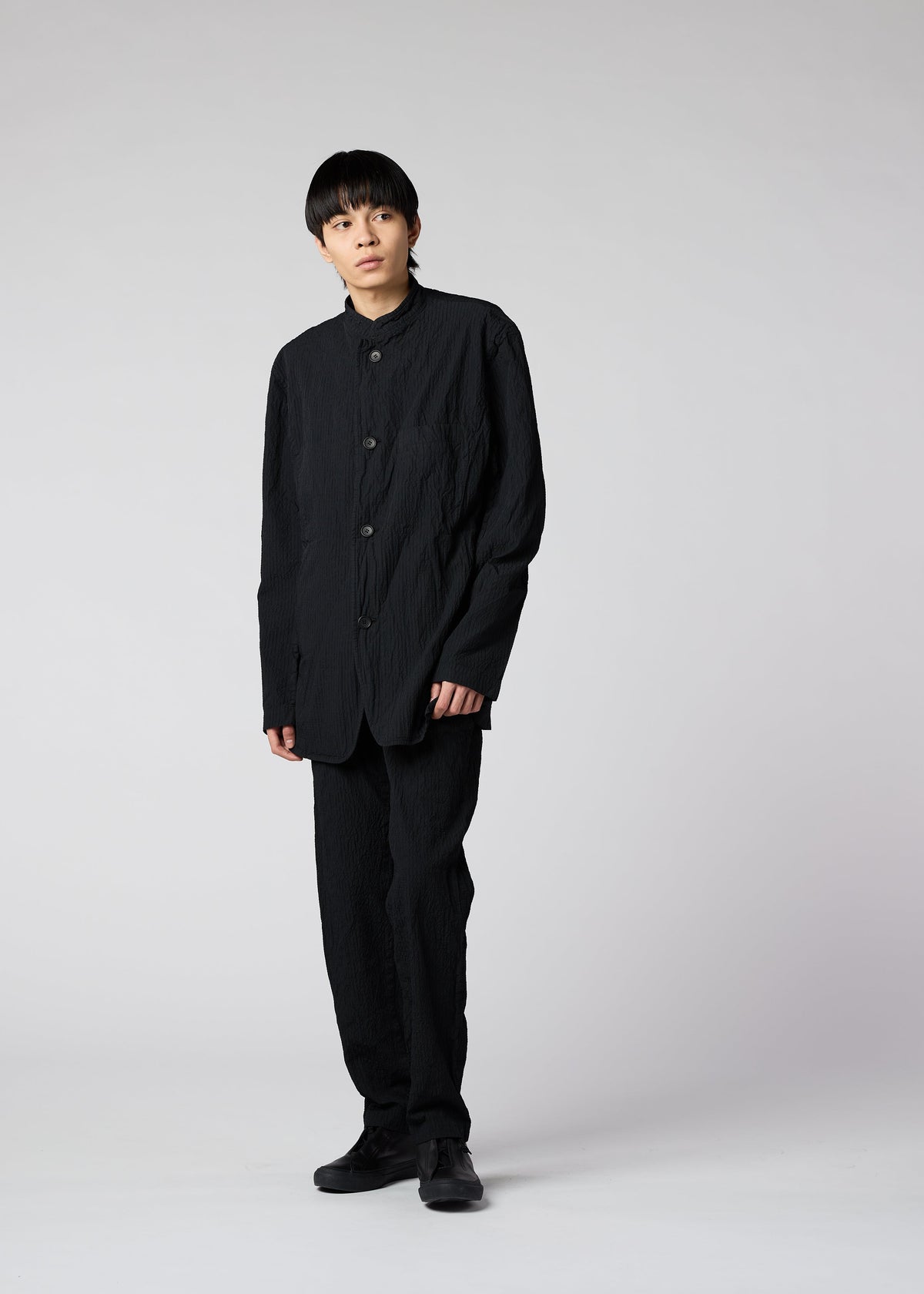 A model wears the IM MEN SHRINK DYE trousers.