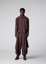 A model wears the IM Men FLAT DRAPE trousers.