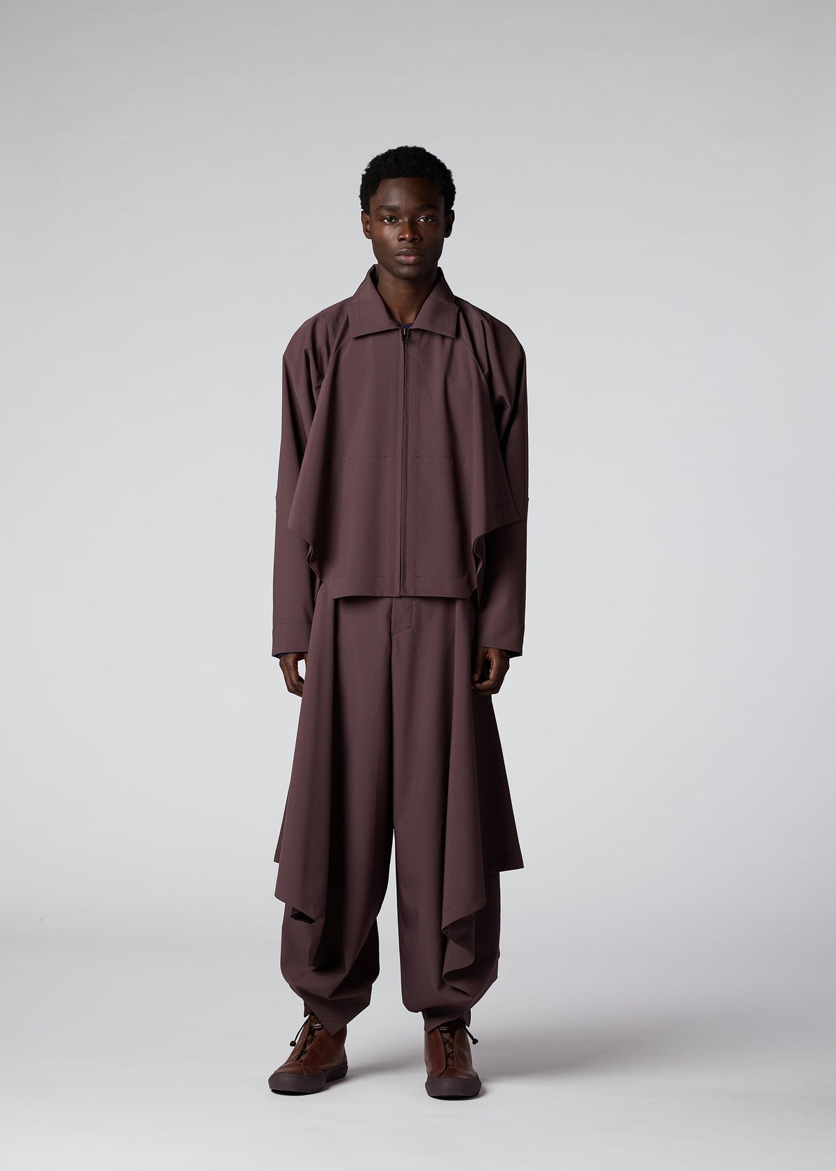 A model wears the IM Men FLAT DRAPE trousers.