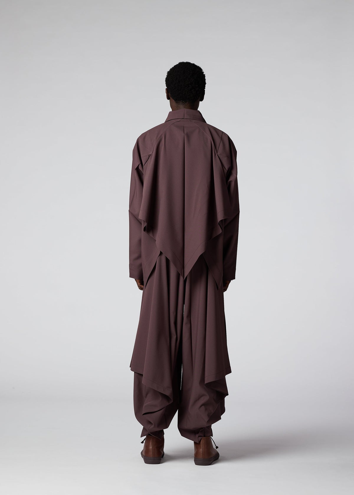 A model wears the IM Men FLAT DRAPE trousers.