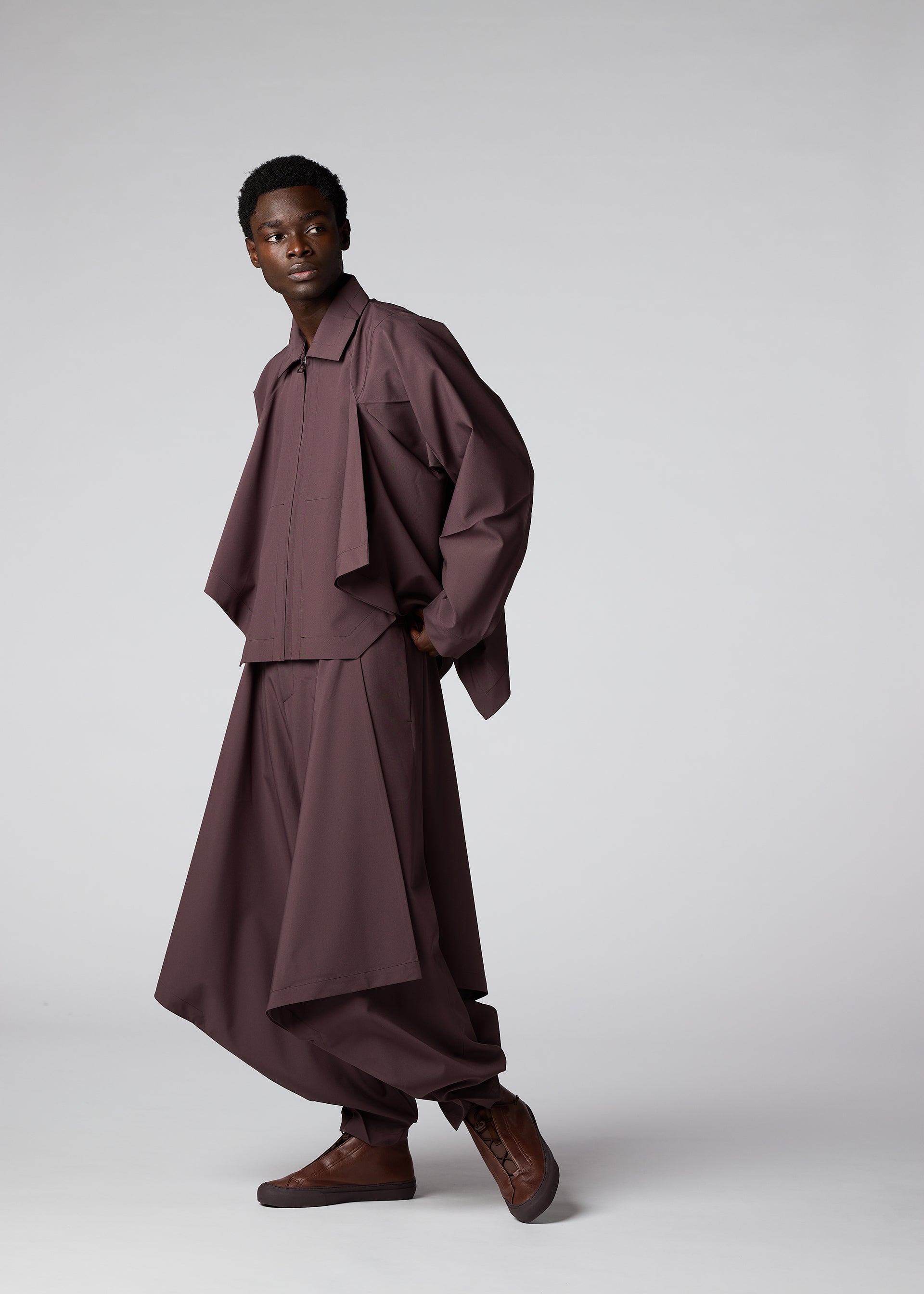 A model wears the IM Men FLAT DRAPE trousers.