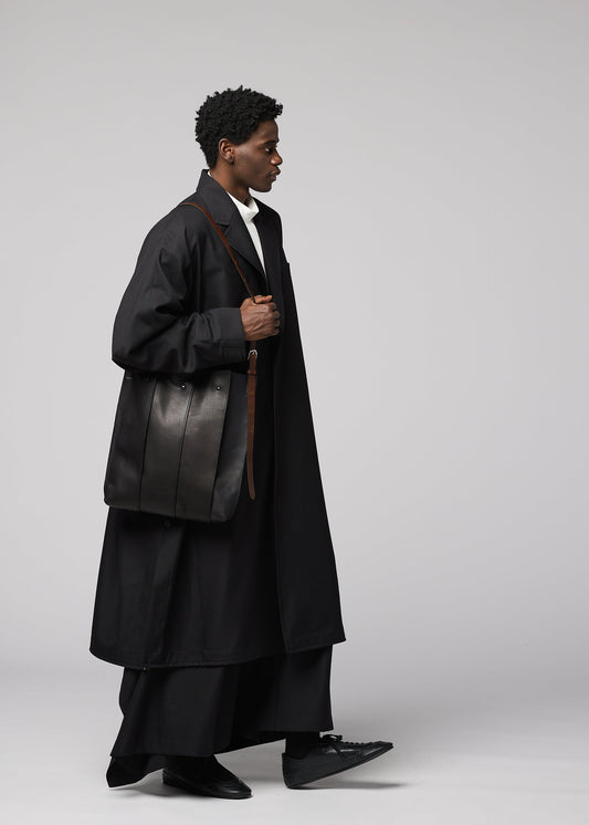 A model wears the IM MEN LEATHER PLEATS bag.