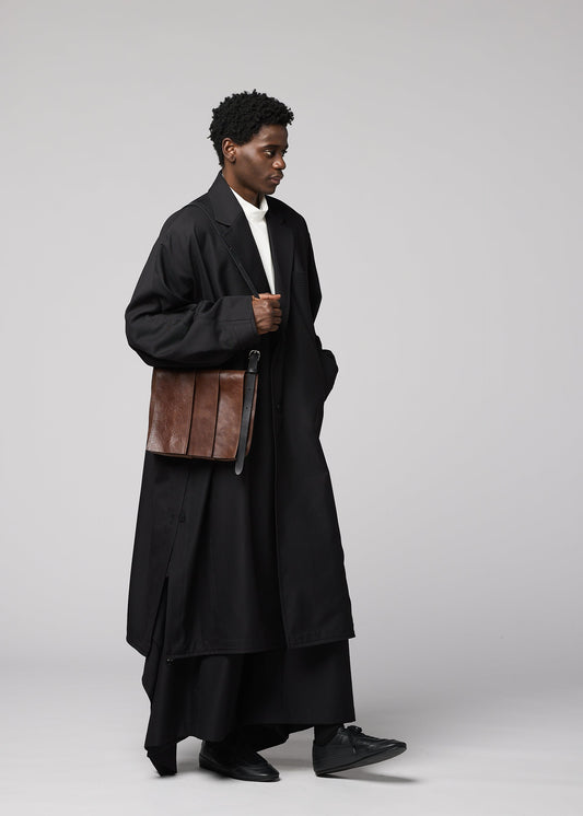 A model wears the IM MEN LEATHER PLEATS bag.