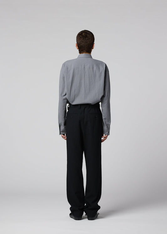 A model wears the IM MEN SHRINK WOOL trousers.
