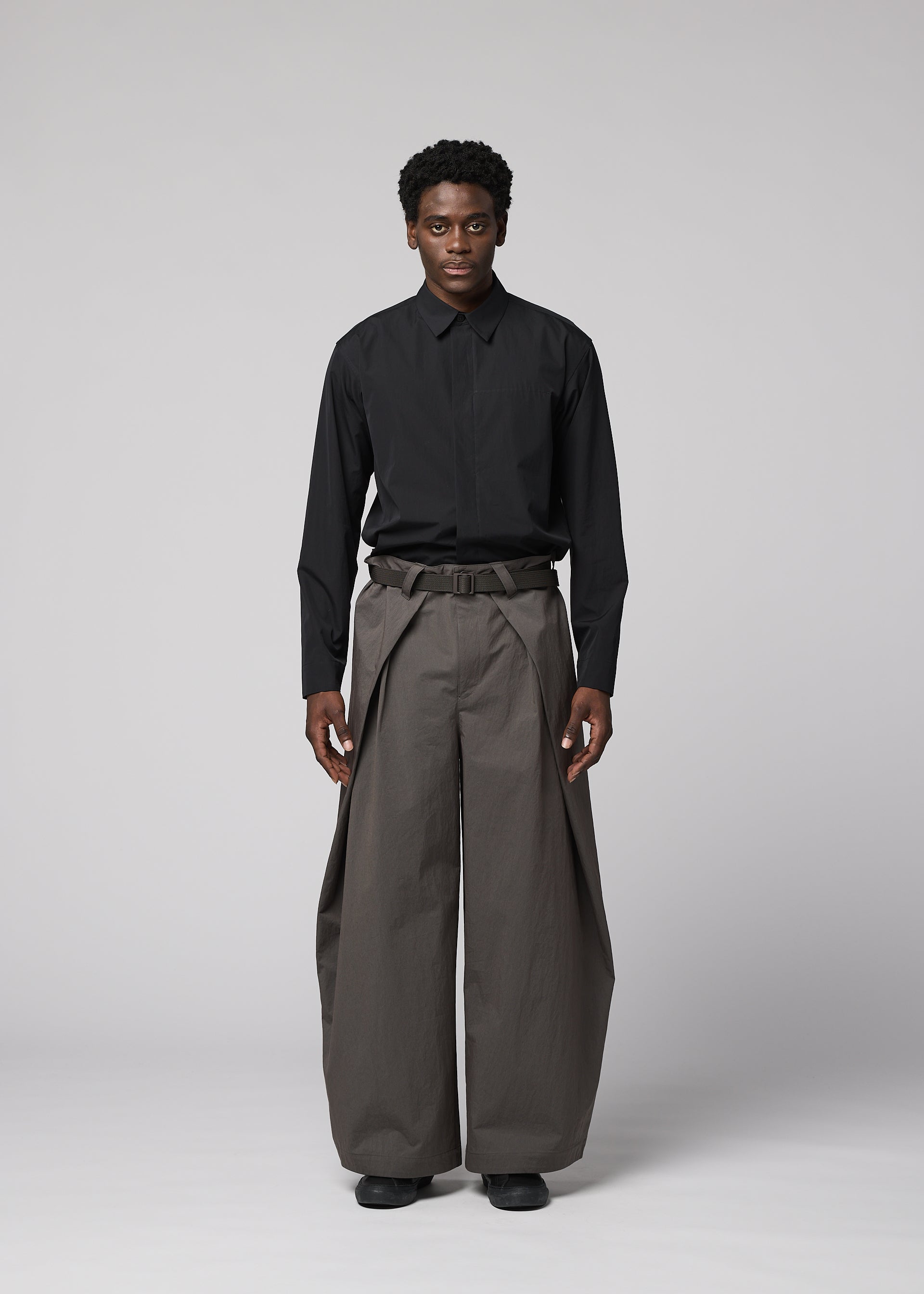 A model wears the IM MEN OVERLAP overlap-trousers-brown.