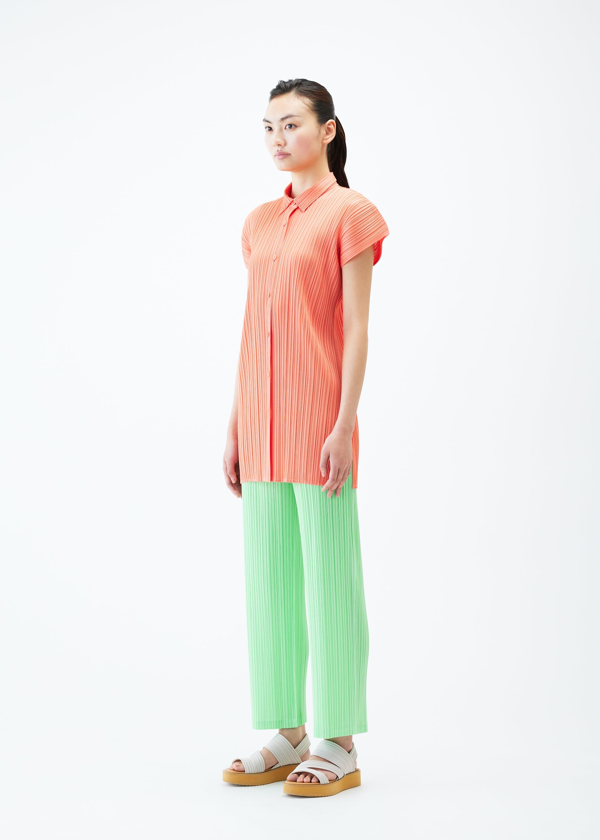 A model wears the PLEATS PLEASE ISSEY MIYAKE MONTHLY COLORS MAY shirt.