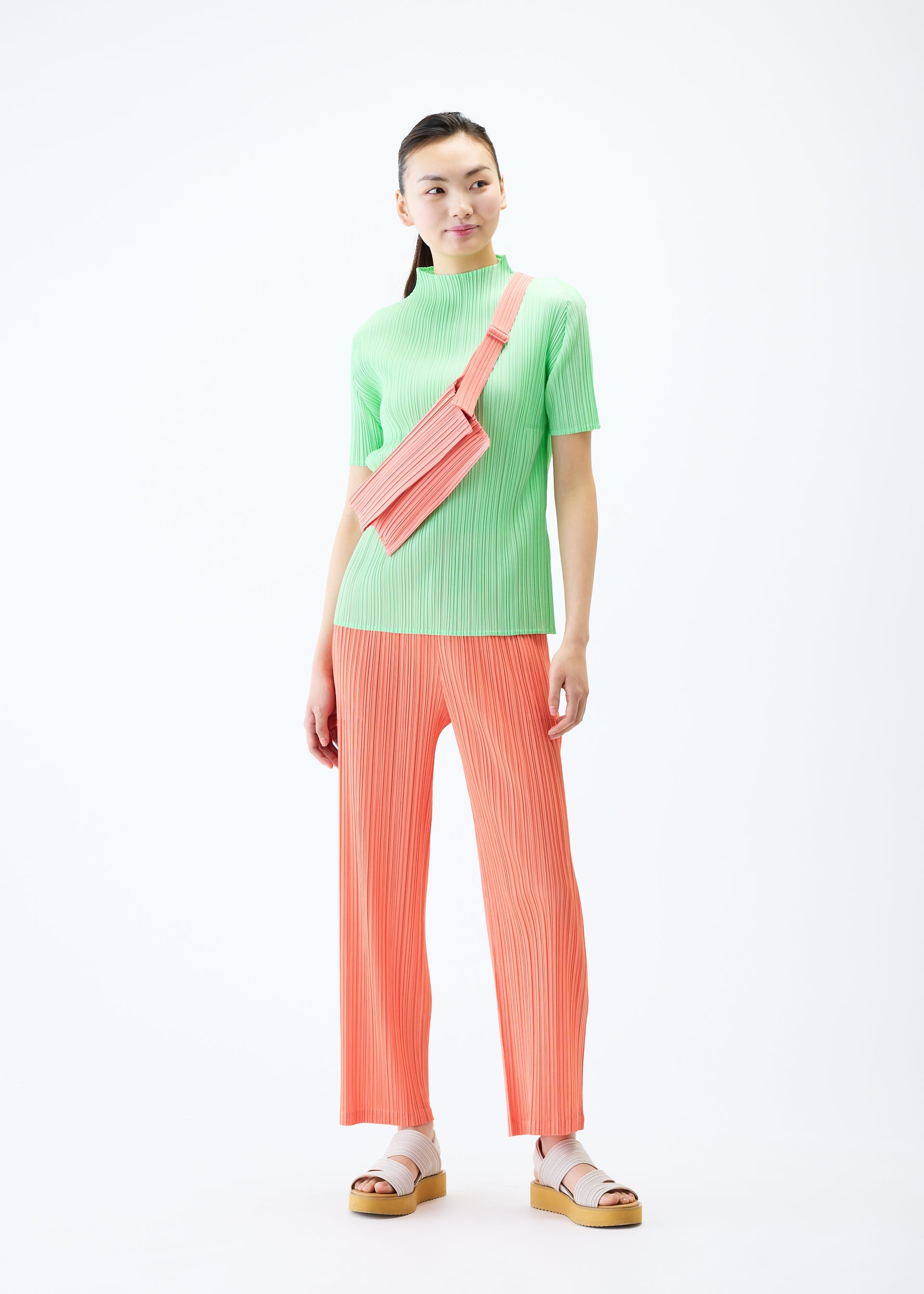 A model wears the PLEATS PLEASE ISSEY MIYAKE PLEATS SACOCHE bag.