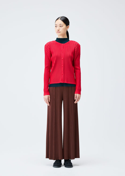 A model wears the Pleats Please Issey Miyake RIB PLEATS NOVEMBER cardigan.