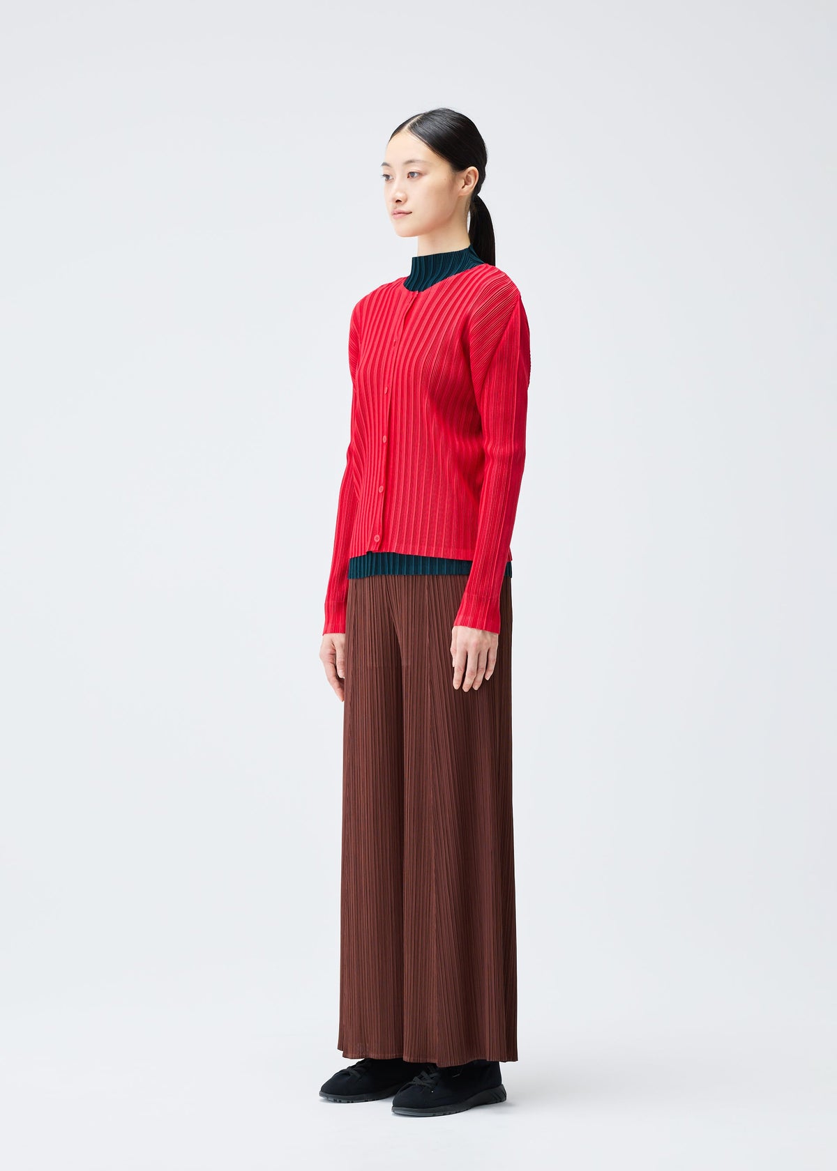 A model wears the Pleats Please Issey Miyake RIB PLEATS NOVEMBER cardigan.