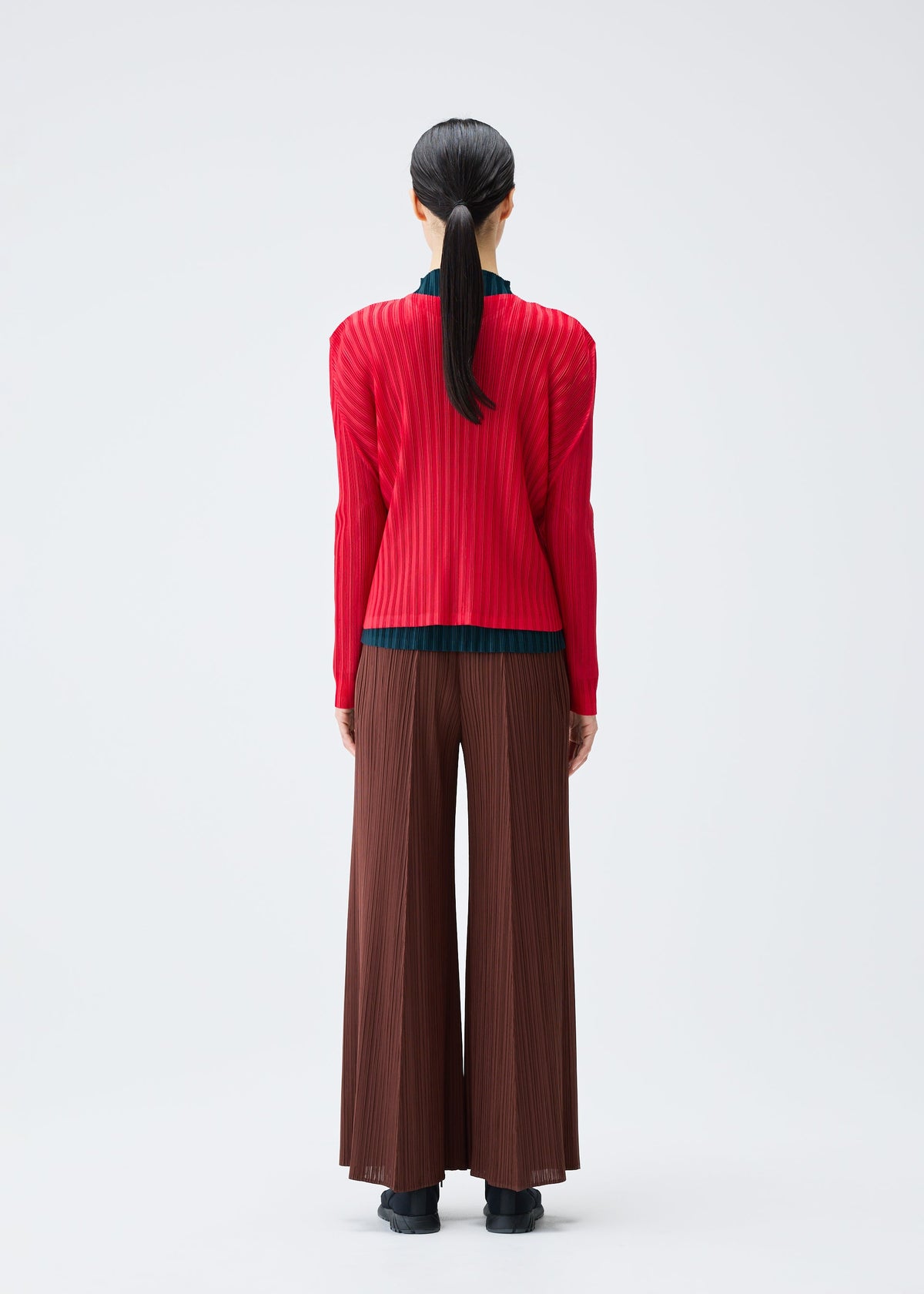 A model wears the Pleats Please Issey Miyake RIB PLEATS NOVEMBER cardigan.