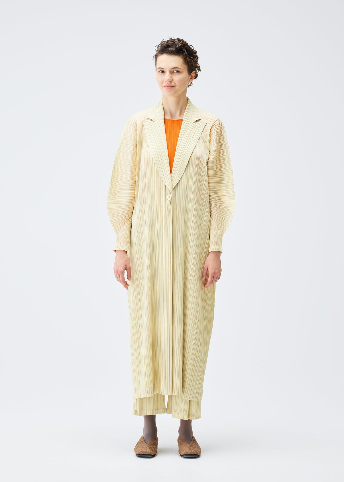 A model wears the Pleats Please Issey Miyake MONTHLY COLORS : DECEMBER coat.