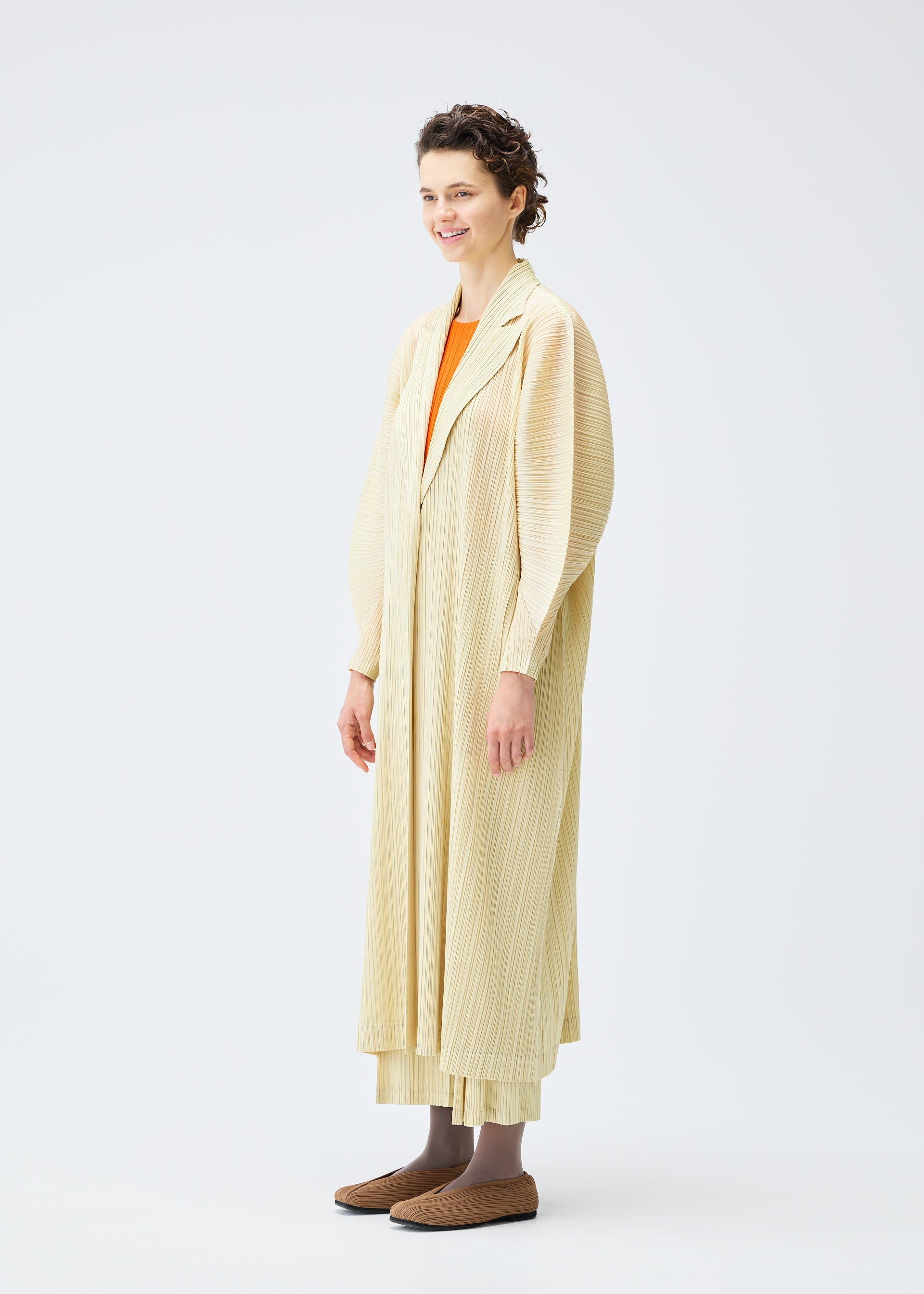A model wears the Pleats Please Issey Miyake MONTHLY COLORS : DECEMBER coat.