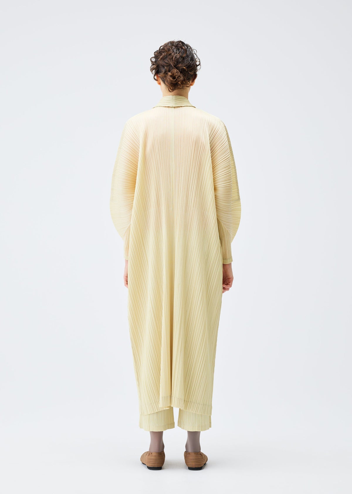 A model wears the Pleats Please Issey Miyake MONTHLY COLORS : DECEMBER coat.