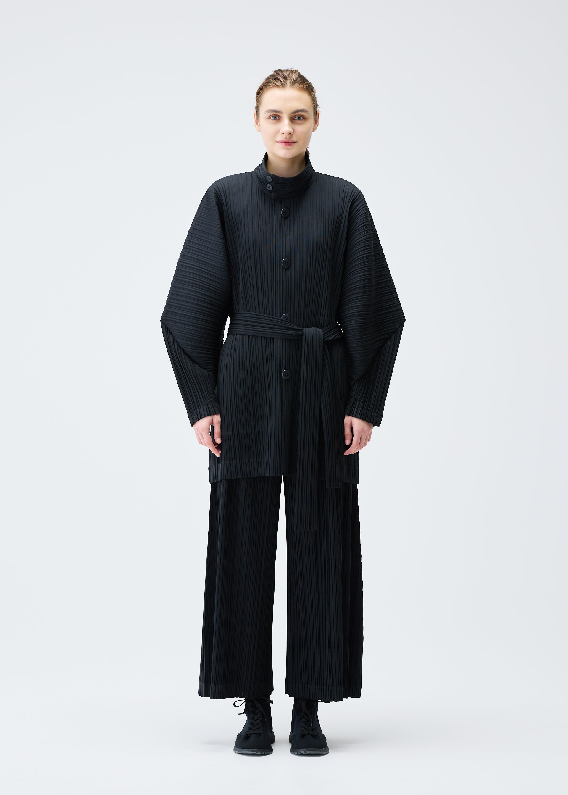 A model wears the Pleats Please Issey Miyake WOOL PLEATS coat.