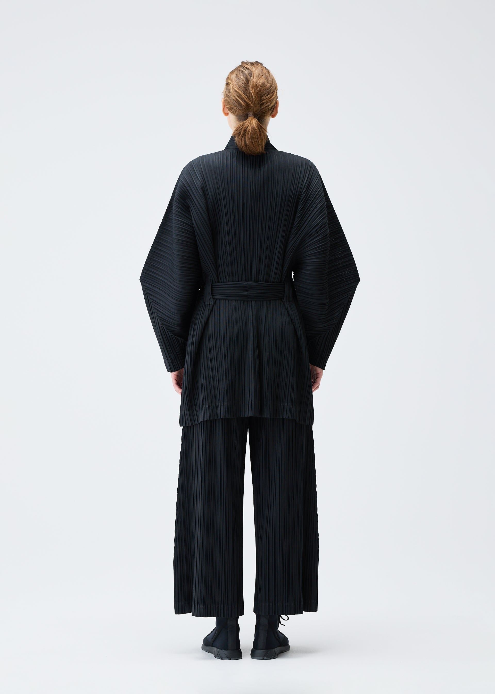 A model wears the Pleats Please Issey Miyake WOOL PLEATS coat.