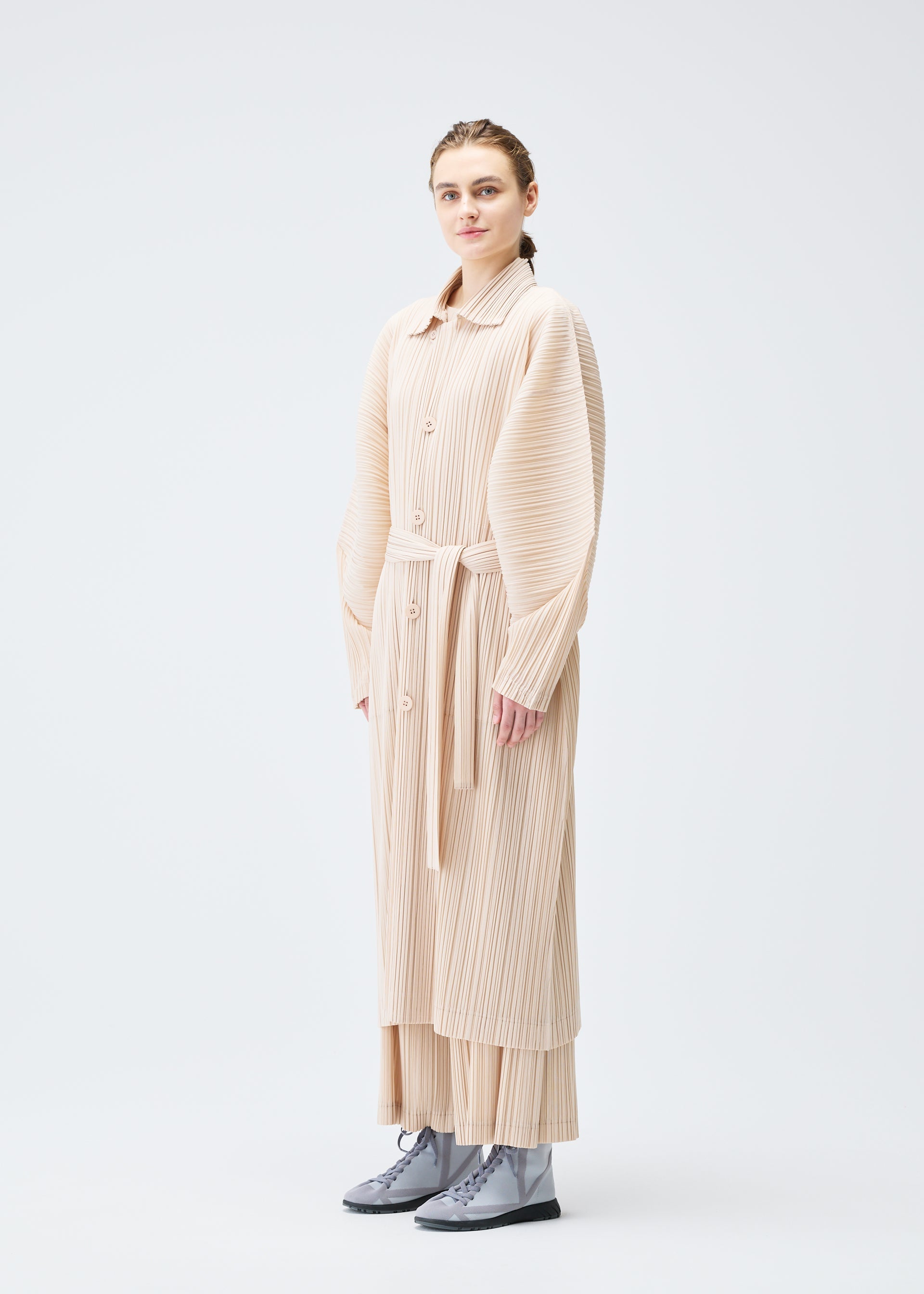A model wears the Pleats Please Issey Miyake WOOL PLEATS coat.