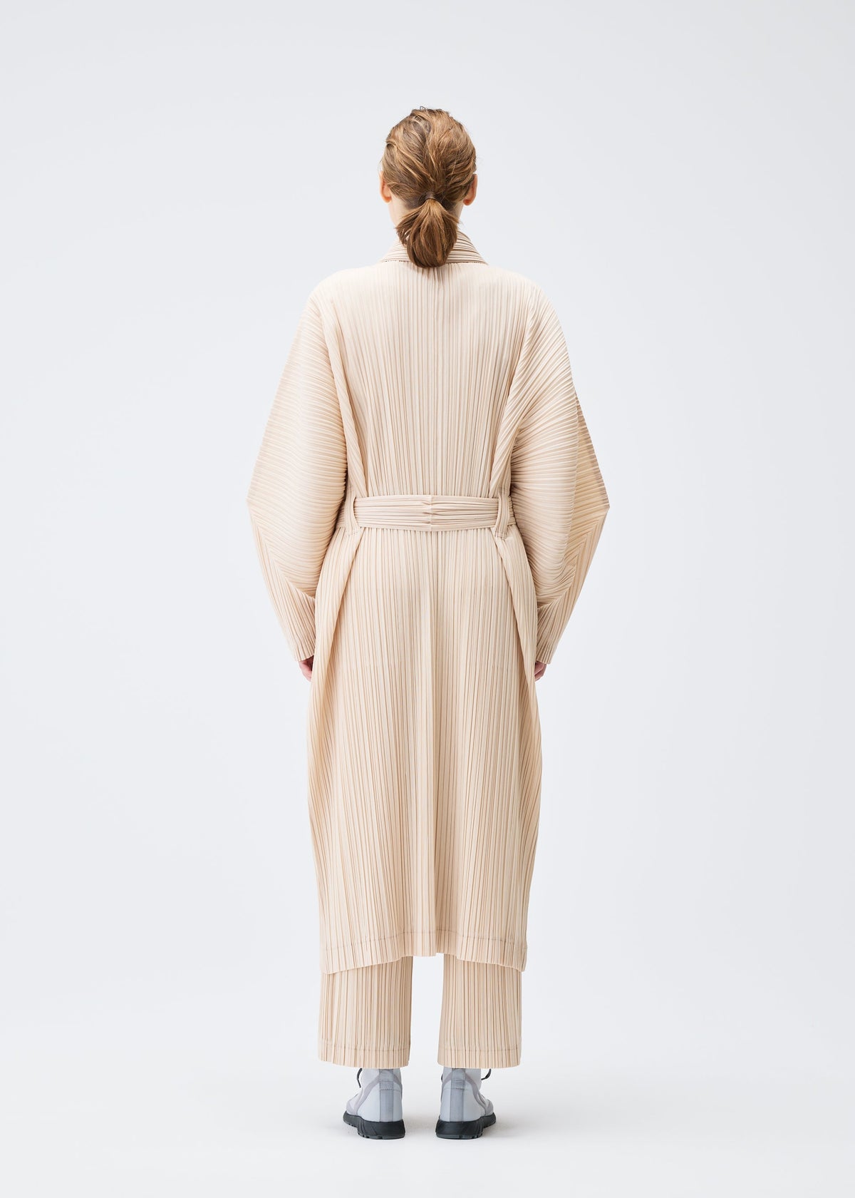 A model wears the Pleats Please Issey Miyake WOOL PLEATS coat.