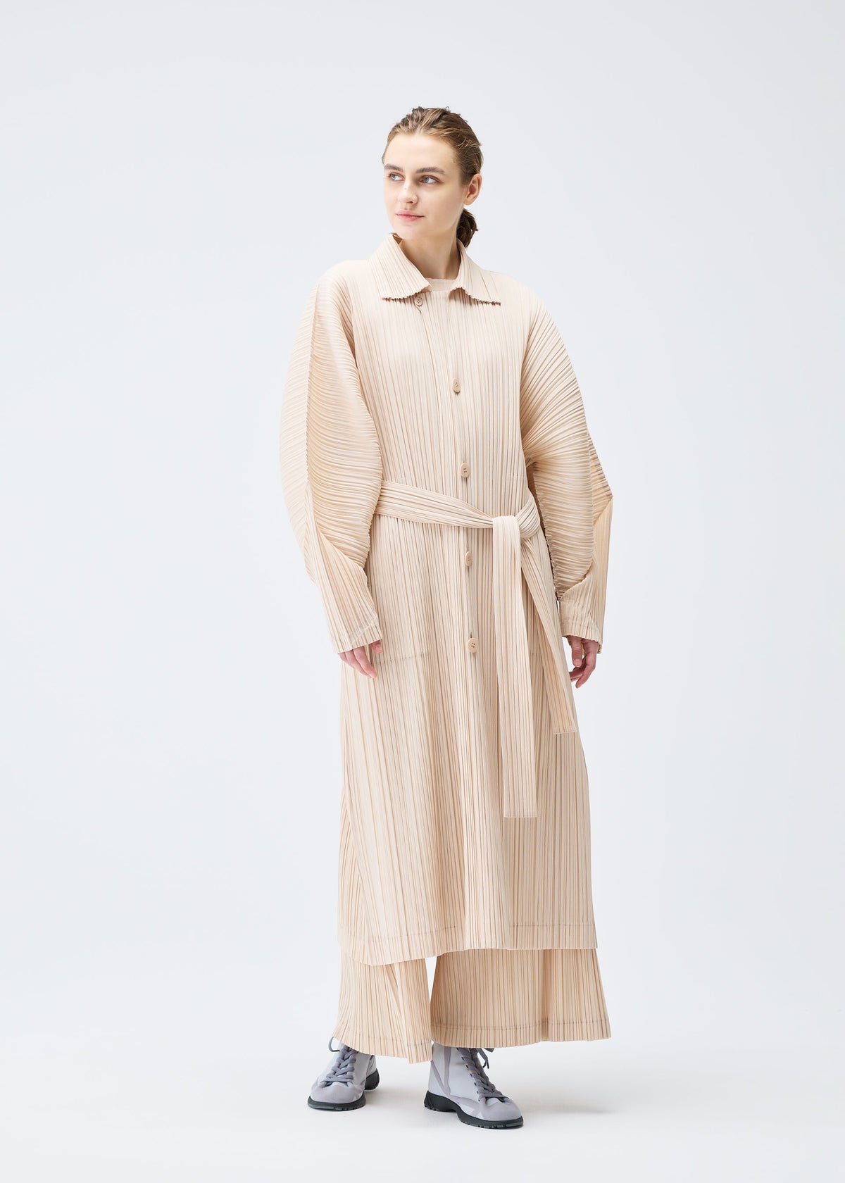 A model wears the Pleats Please Issey Miyake WOOL PLEATS coat.