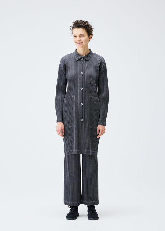 A model wears the PLEATS PLEASE ISSEY MIYAKE COTTON DENIM coat.