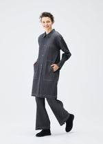 A model wears the PLEATS PLEASE ISSEY MIYAKE COTTON DENIM coat.