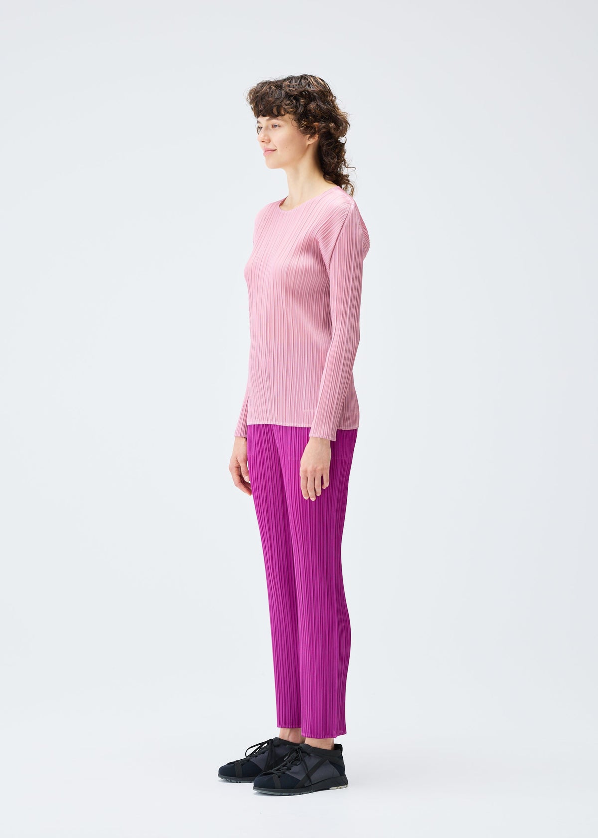 A model wears the Pleats Please Issey Miyake MONTHLY COLORS SEPTEMBER trousers.