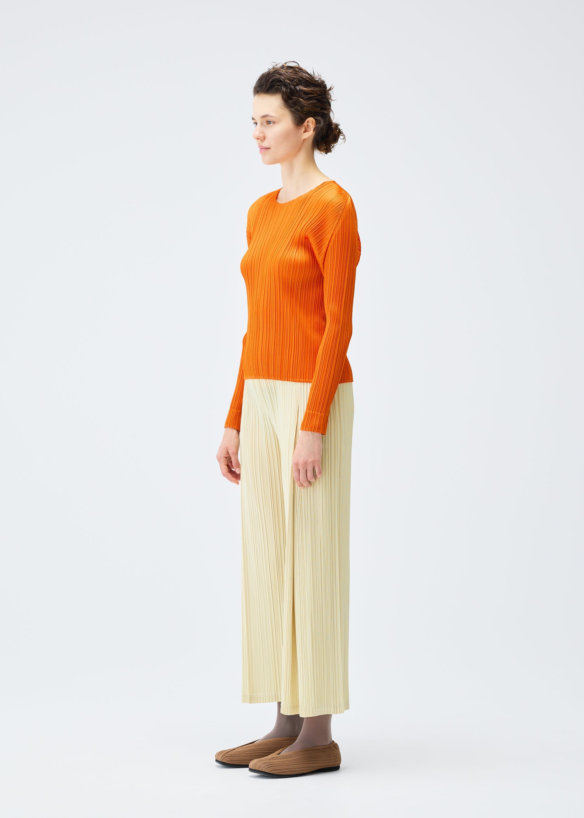 A model wears the Pleats Please Issey Miyake MONTHLY COLORS : DECEMBER trousers.