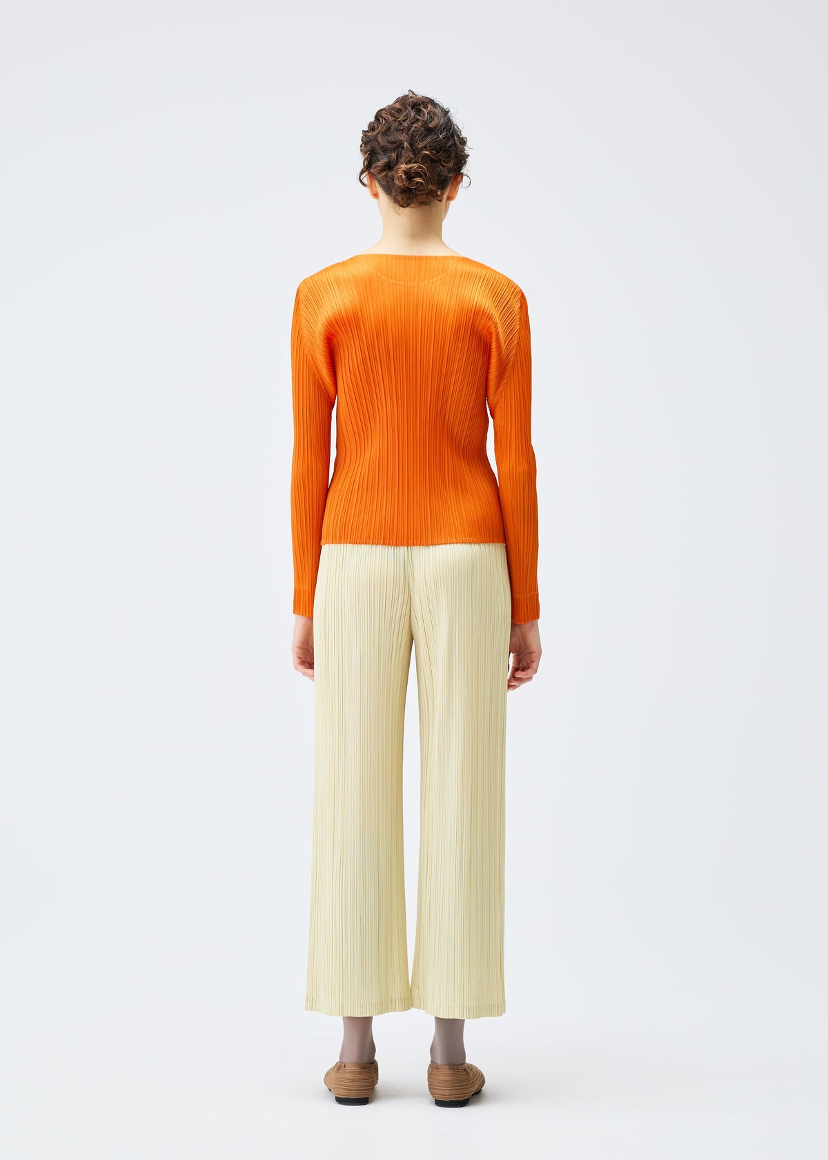 A model wears the Pleats Please Issey Miyake MONTHLY COLORS : DECEMBER trousers.