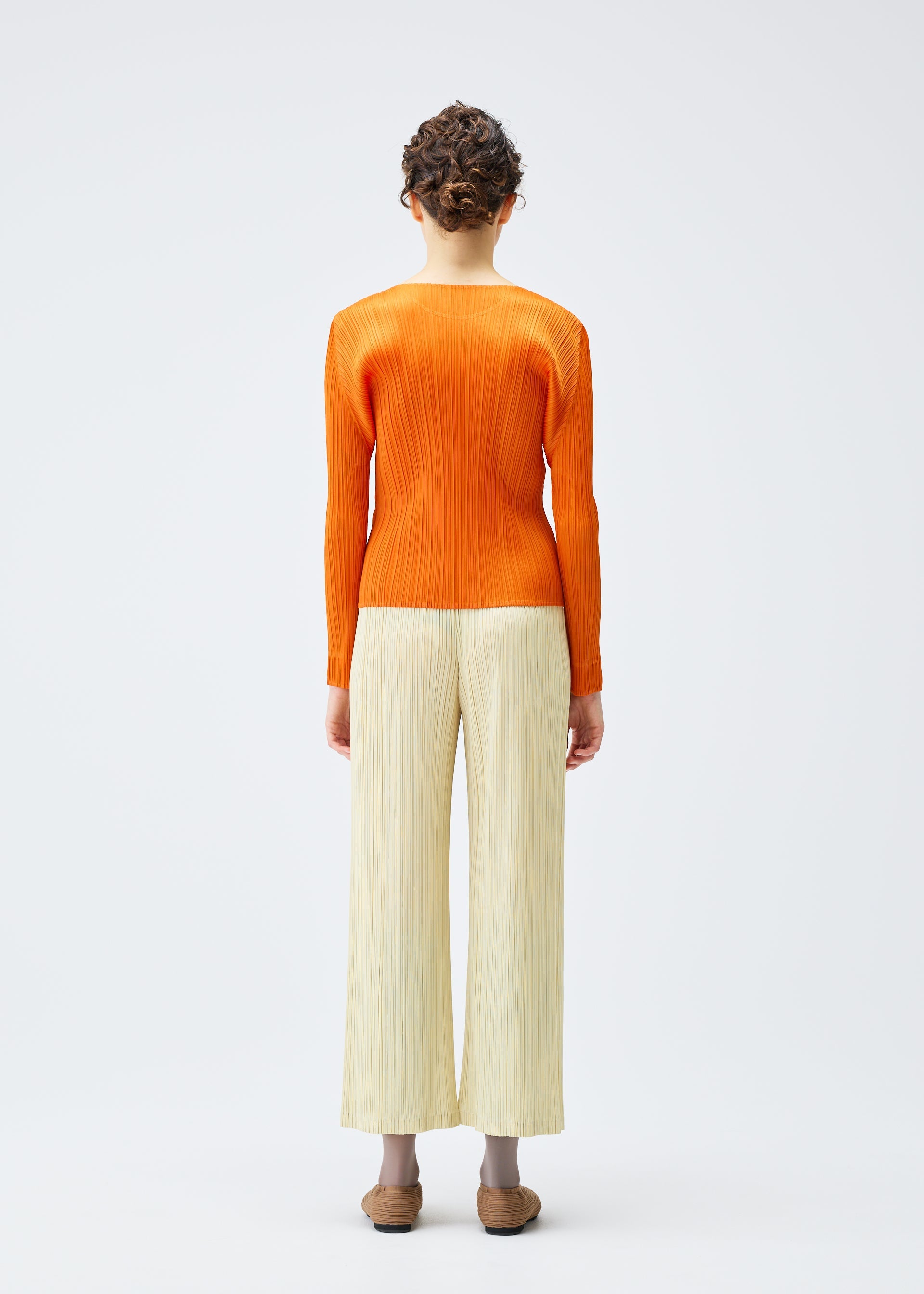 A model wears the Pleats Please Issey Miyake MONTHLY COLORS : DECEMBER trousers.