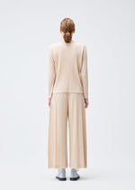 A model wears the Pleats Please Issey Miyake WOOL PLEATS trousers.