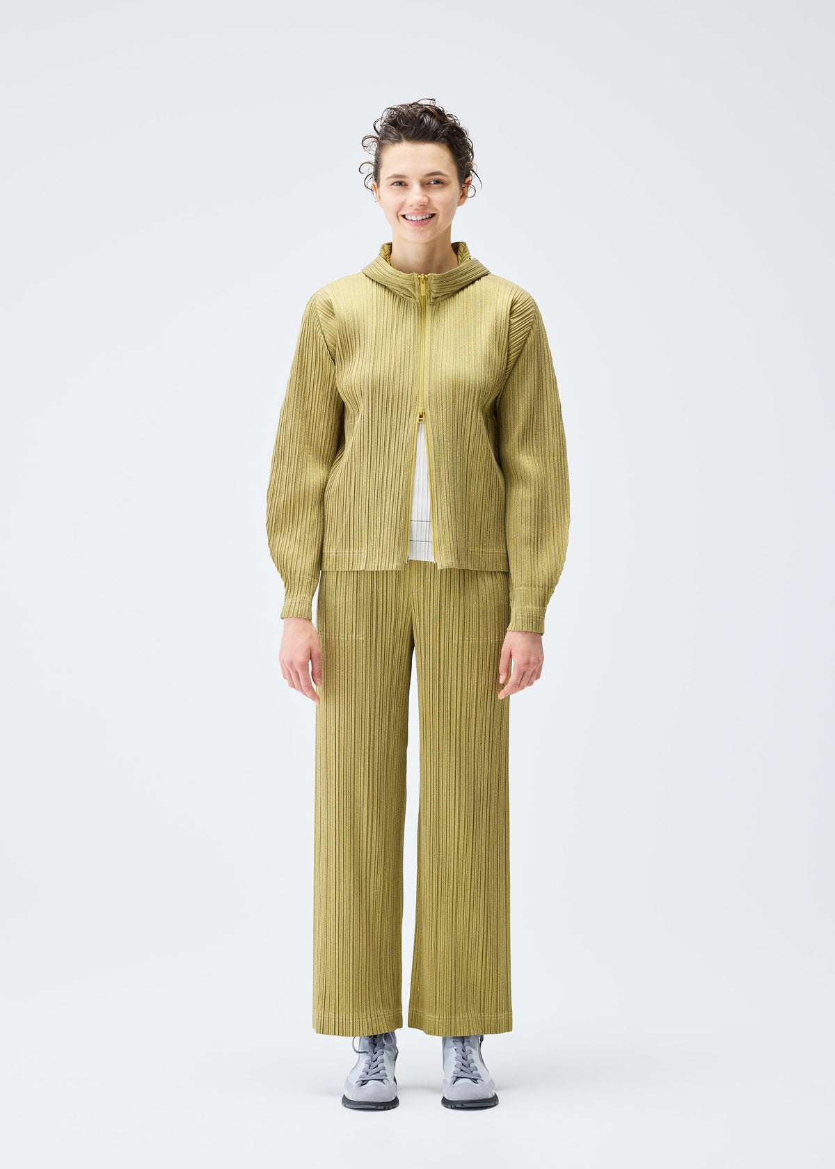 A model wears the PLEATS PLEASE ISSEY MIYAKE COTTON DENIM trousers.