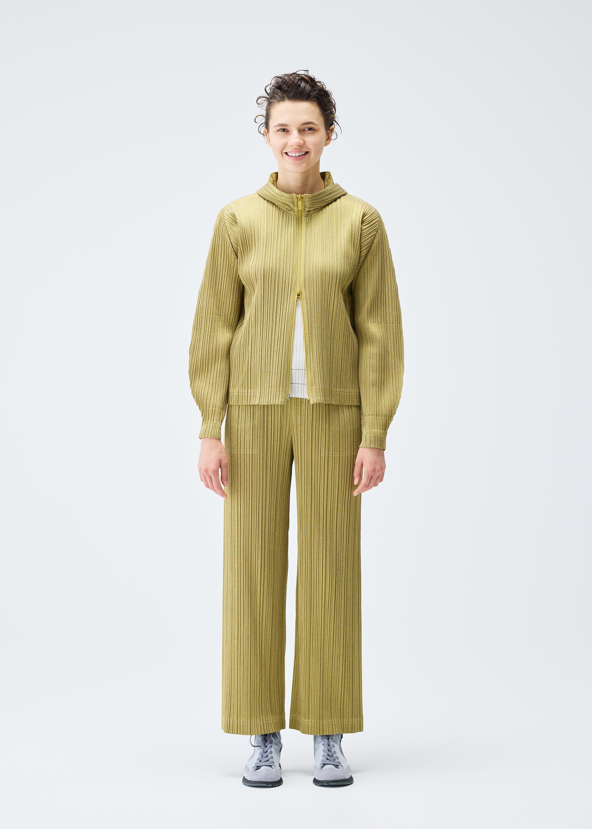 A model wears the PLEATS PLEASE ISSEY MIYAKE COTTON DENIM trousers.