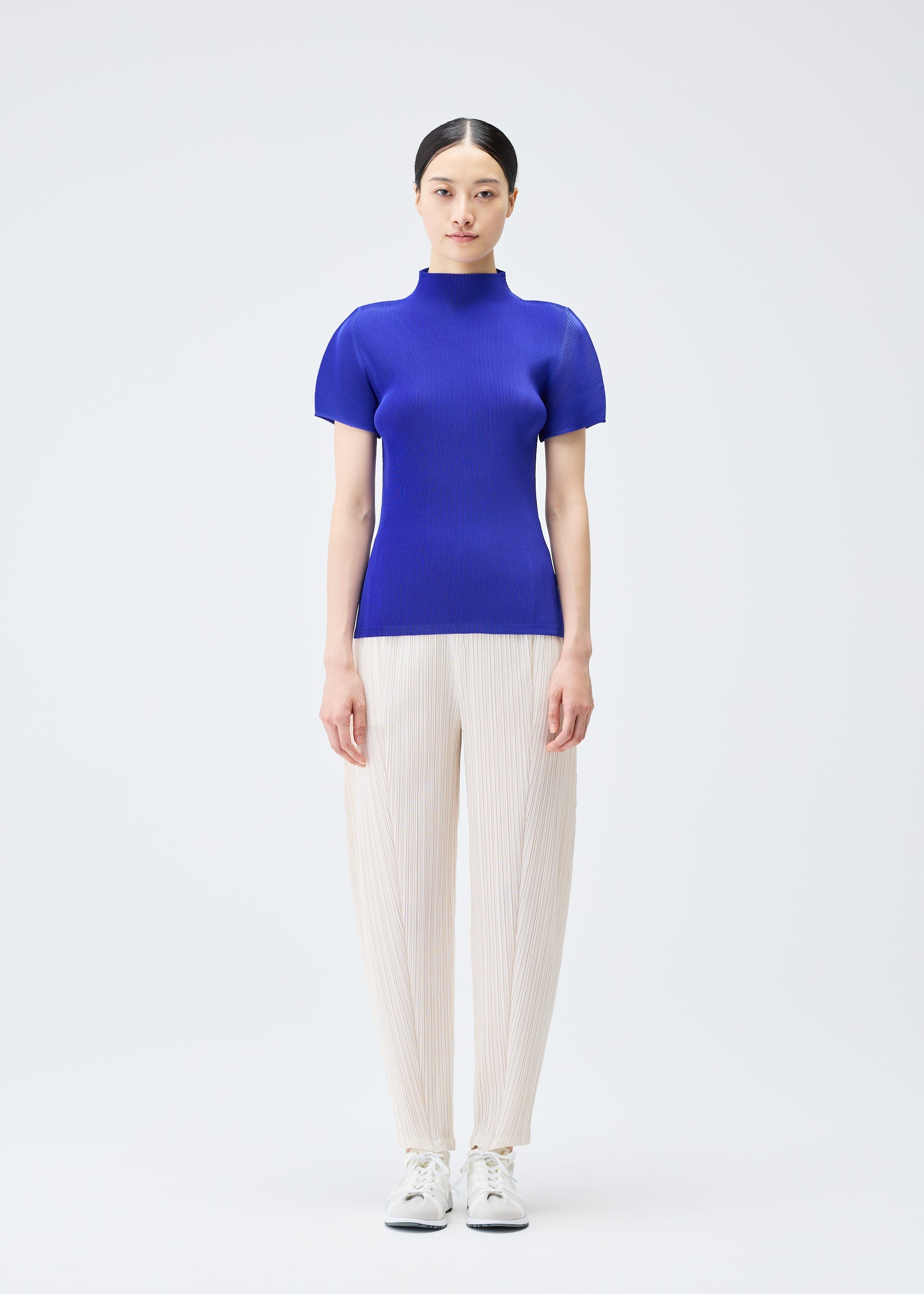 A model wears the Pleats Please Issey Miyake THICKER BOTTOMS 2 trousers.