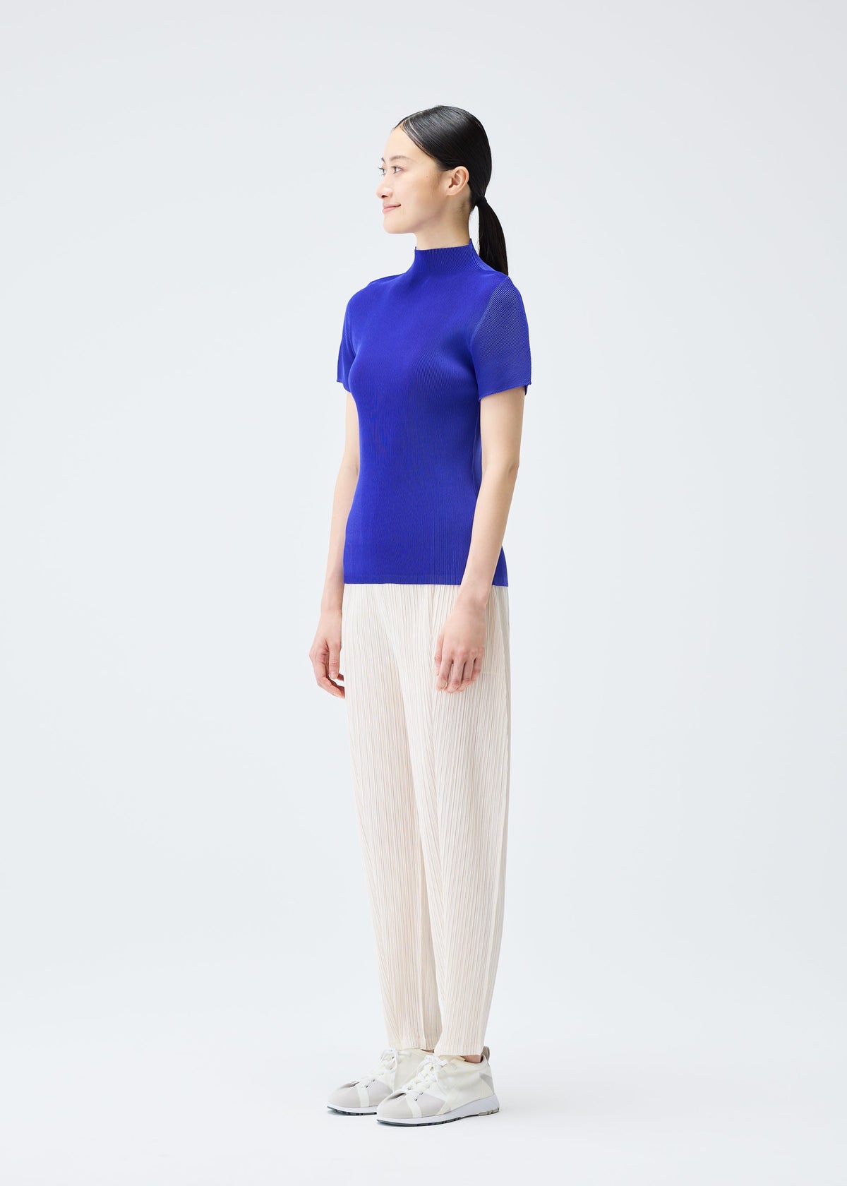 A model wears the Pleats Please Issey Miyake THICKER BOTTOMS 2 trousers.